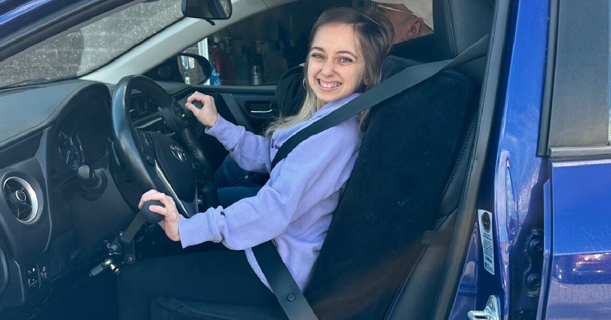 Shauna Rae driving a car with adaptive hand controls