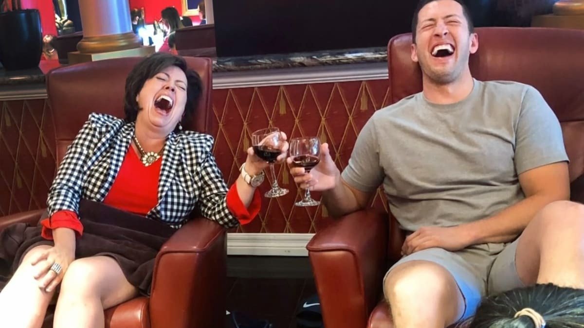 Kelly and Matt laughing together while holding wine glasses