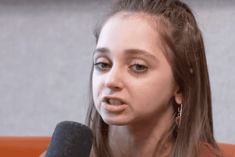 Shauna Rae speaking into a microphone in a close-up interview