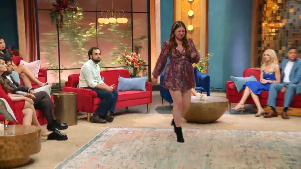 Catie Norboe walking off the Tell All stage in tears while Josh watches