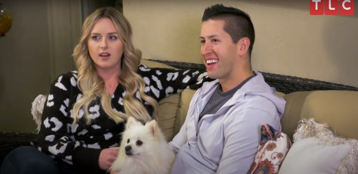 Kim and Matt sitting on a sofa with their dog on I Love a Mama's Boy