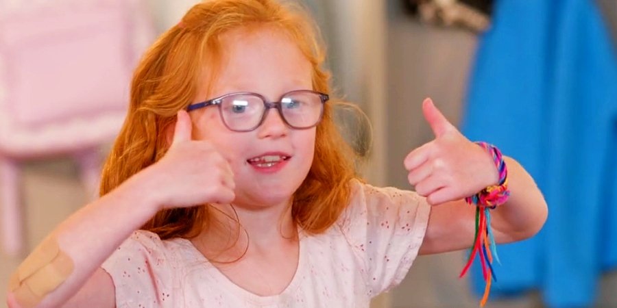Hazel Busby smiling and giving two thumbs up while wearing glasses