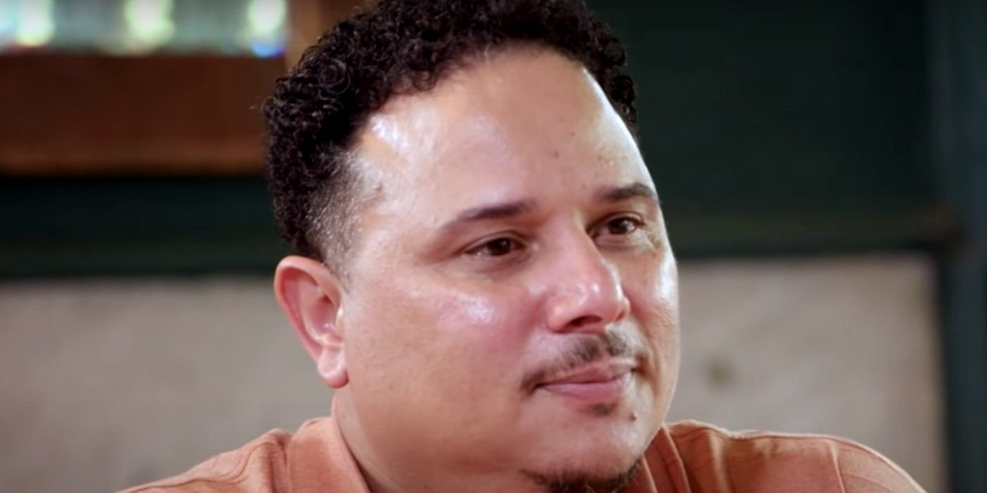 Thomas Everett smiling in a beige shirt while talking to the cameras