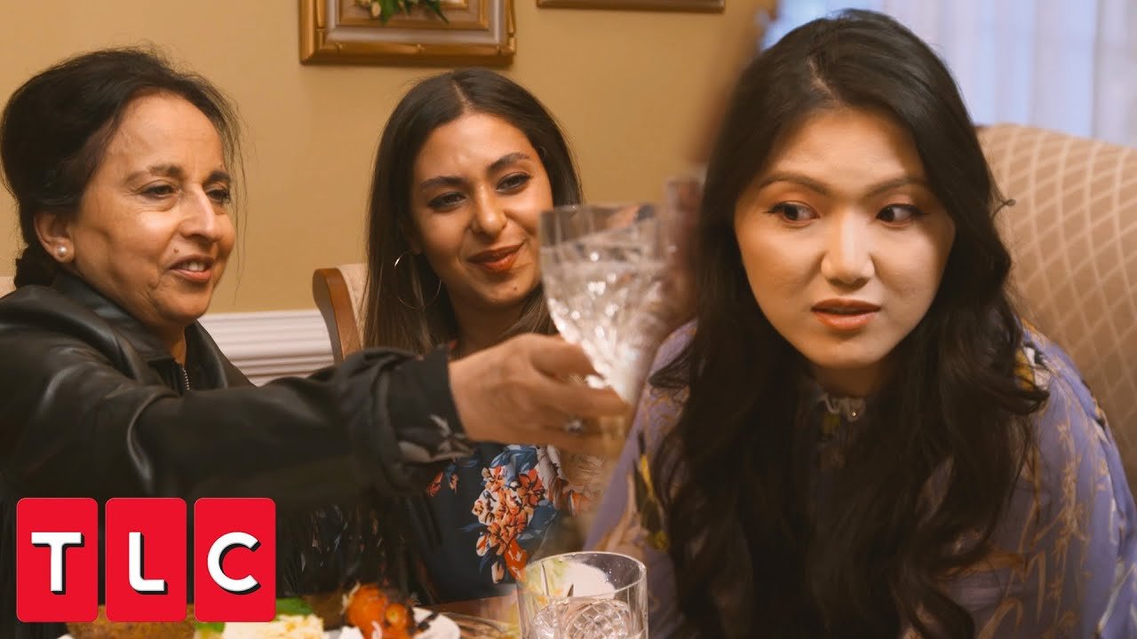 Laila and Yussra at the dinner party as Emily looks on