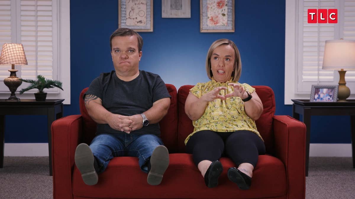Trent and Amber Johnston sitting together on a red couch