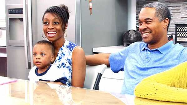 Karen and Deon Derrico smiling in a kitchen with a young child