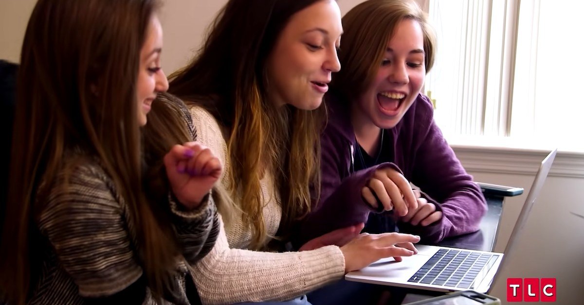Shauna Rae laughing with her sisters around a laptop
