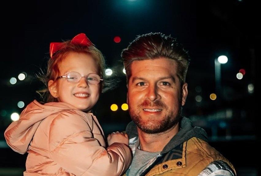 Uncle Dale Mills holding young Hazel Busby at night