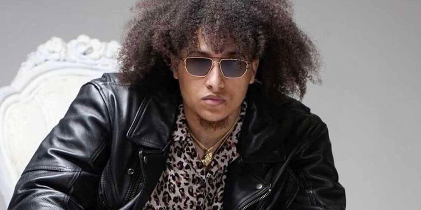 River Everett with curly hair, wearing a leather jacket and sunglasses