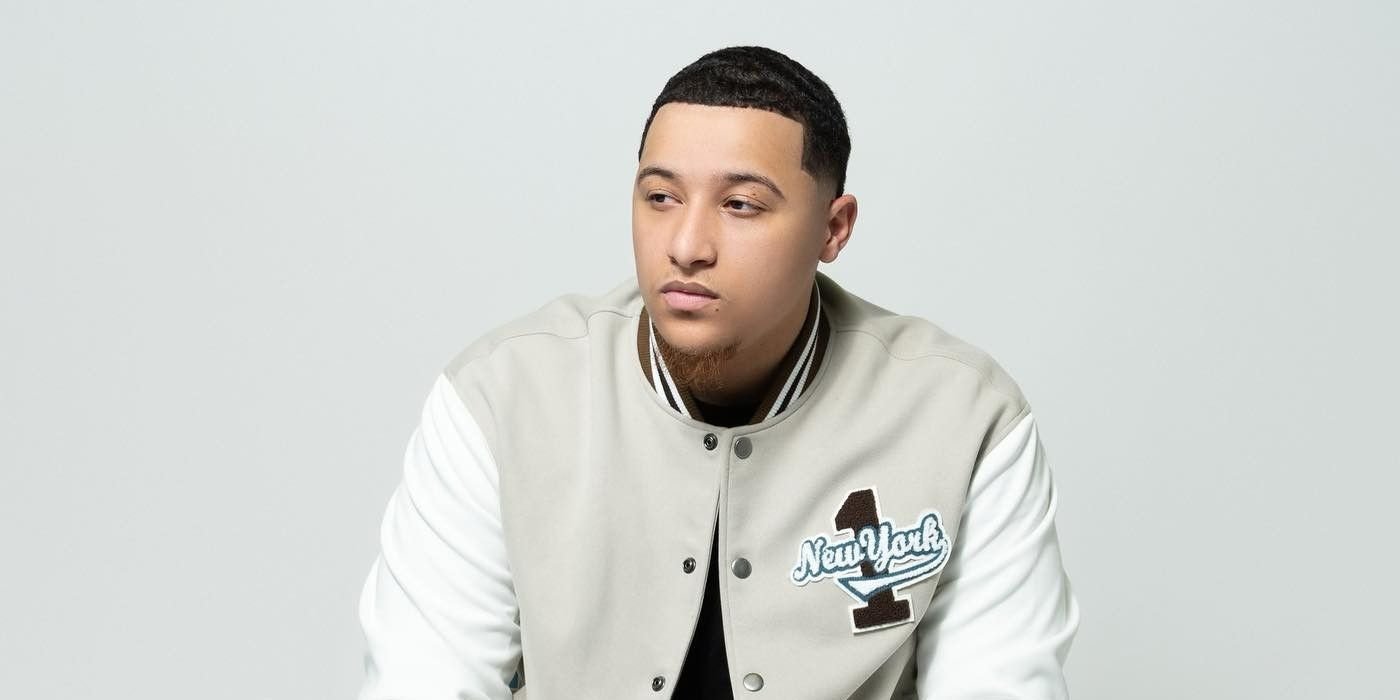 River Everett in a baseball jacket, looking to the side