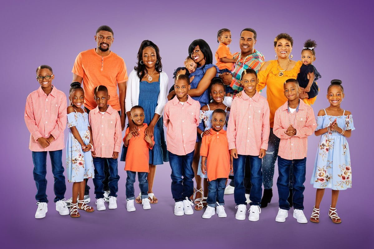 The Derrico family posing together against a purple backdrop