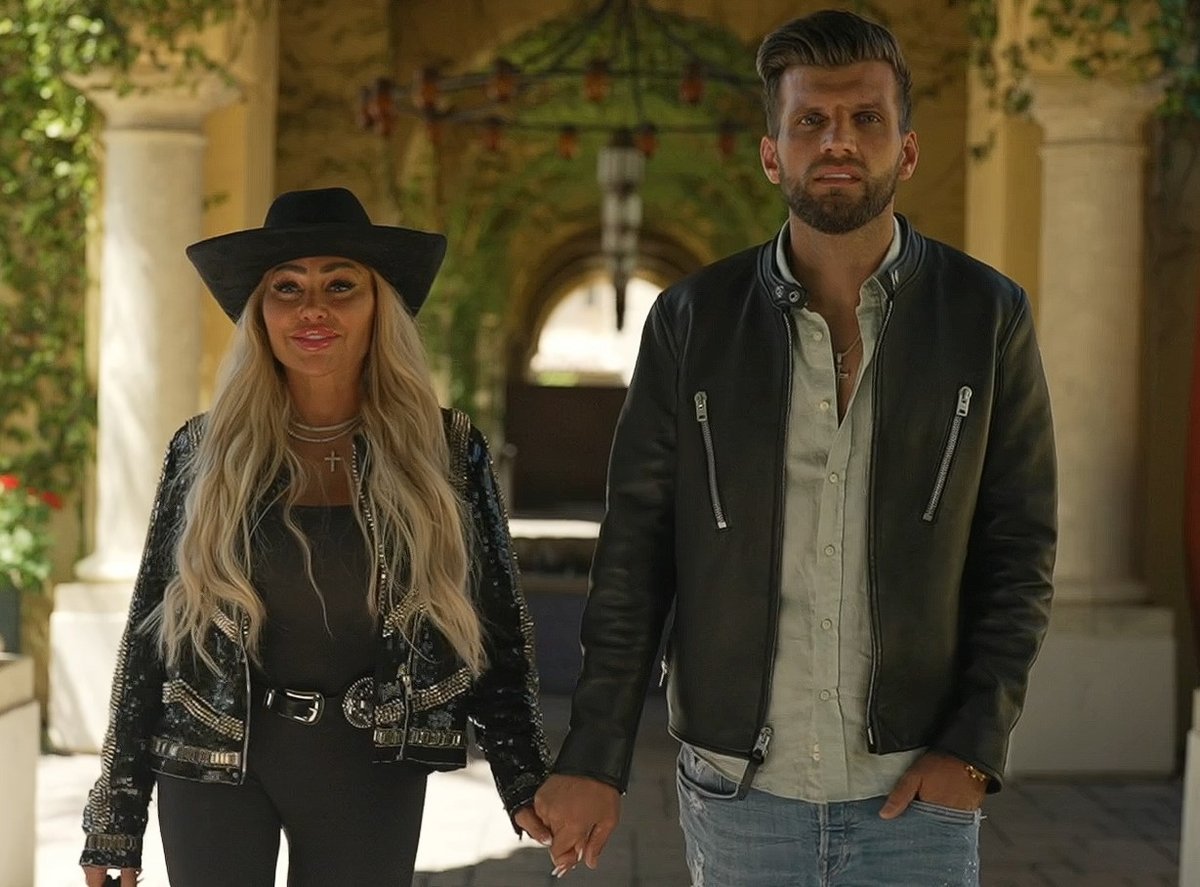Stacey Silva and Florian Sukaj holding hands at a resort