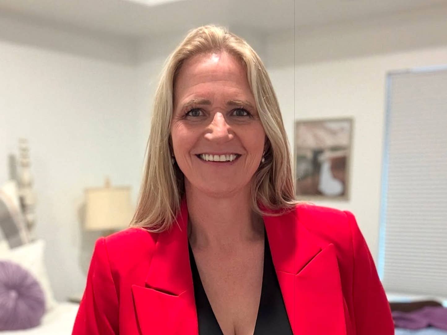 Christine Brown smiling in a red blazer