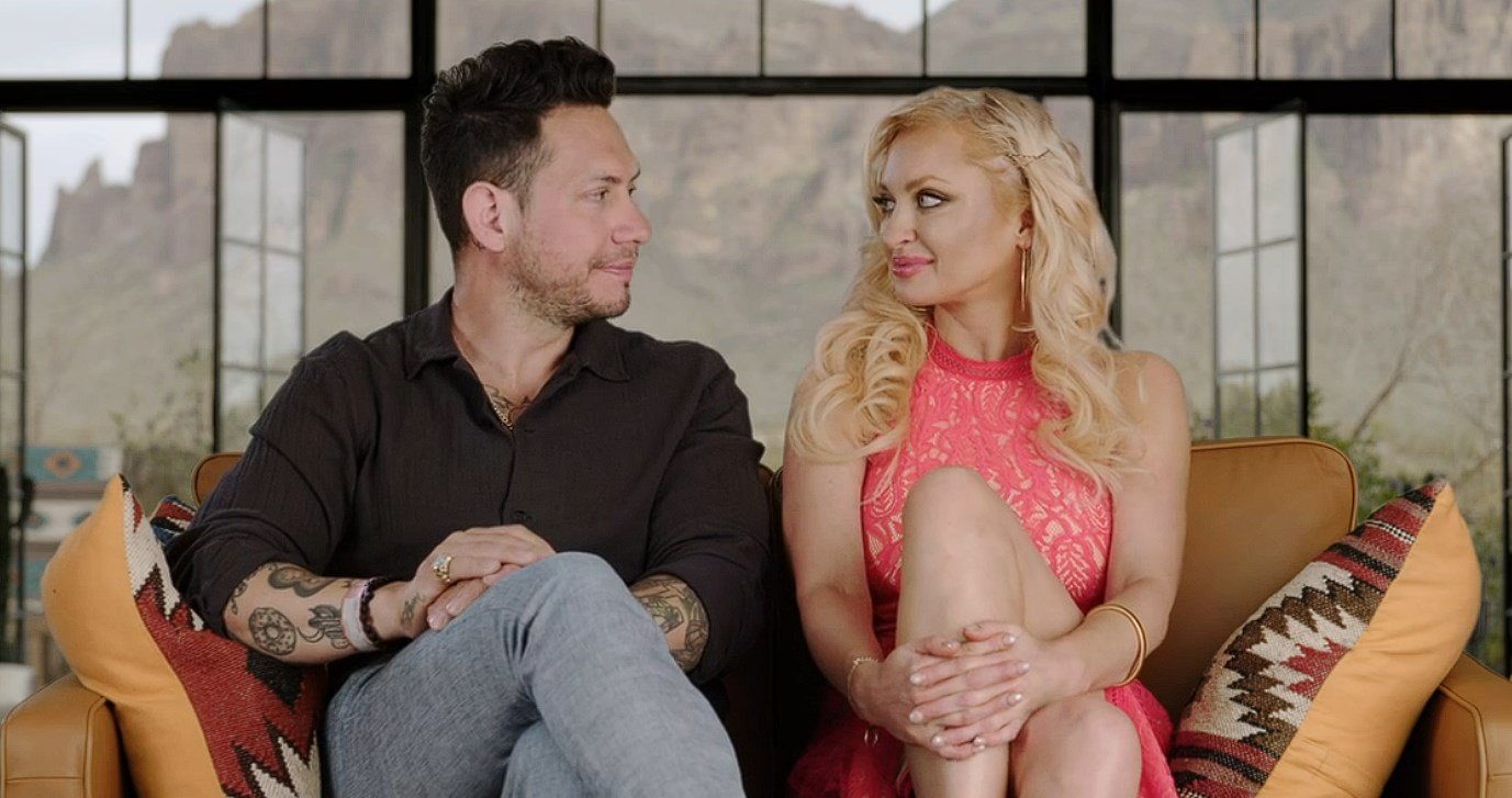 Josh Weinstein and Natalie Mordovtseva sitting together on a sofa
