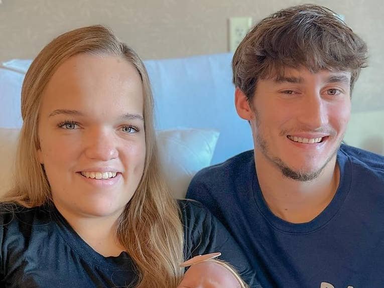 Liz Johnston and Brice Bolden smiling with their newborn baby