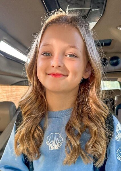 Olivia Busby smiling in a car, older