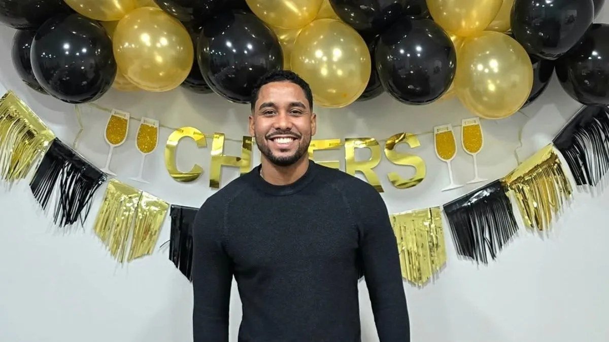 Pedro Jimeno smiling in front of gold and black balloons