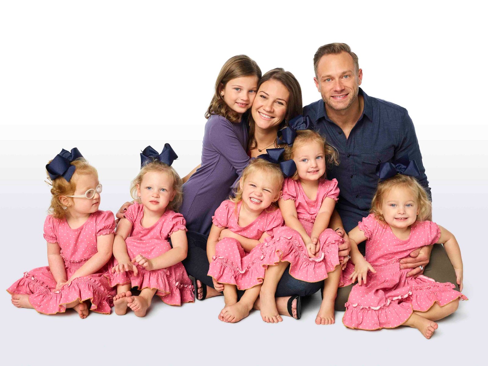 The Busby family with the five quints in matching pink dresses as toddlers