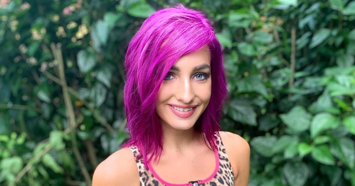 Moriah Plath with magenta hair smiling outdoors