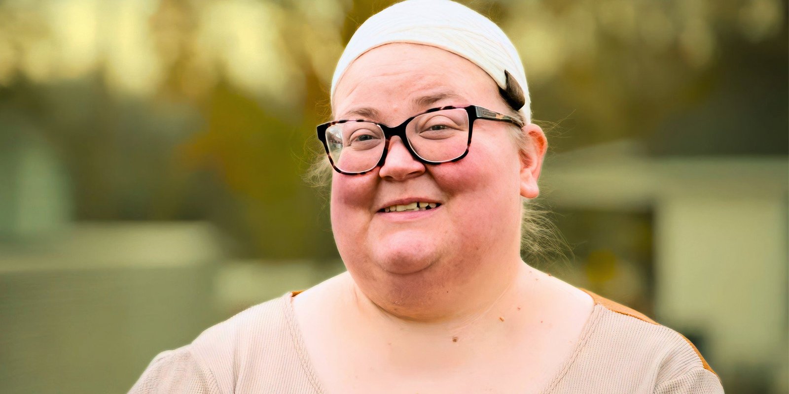 Amanda Halterman smiling in a headscarf and glasses