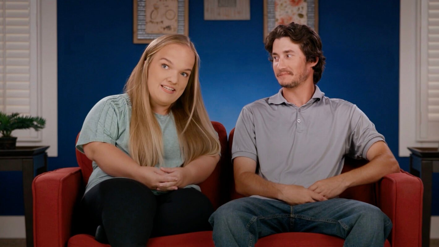 Liz Johnston and Brice Bolden sitting together in a confessional