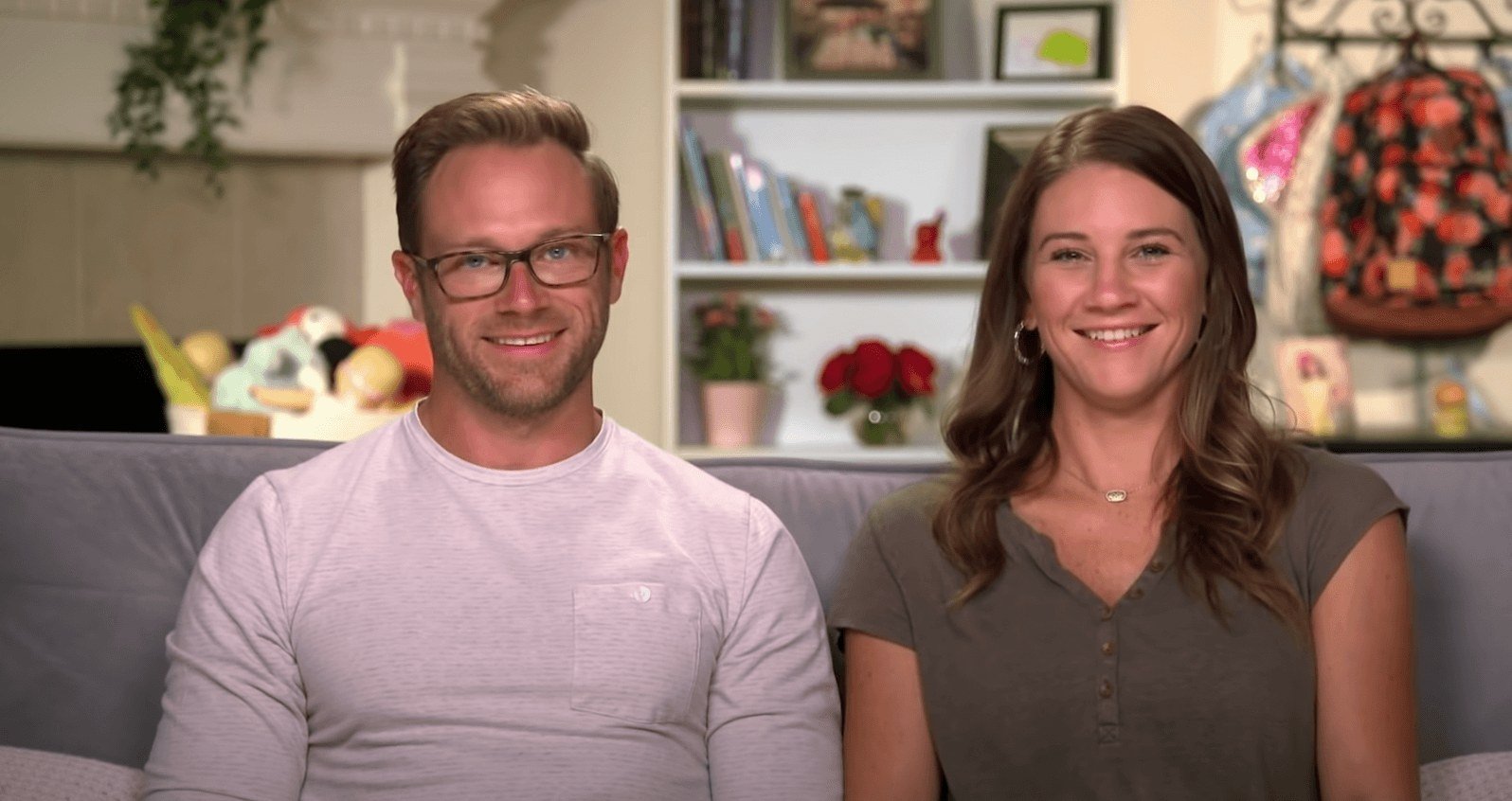 Adam and Danielle Busby smiling together in a confessional