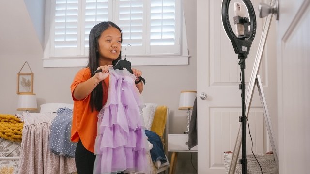 Emma Johnston holding up a dress in a recent season still