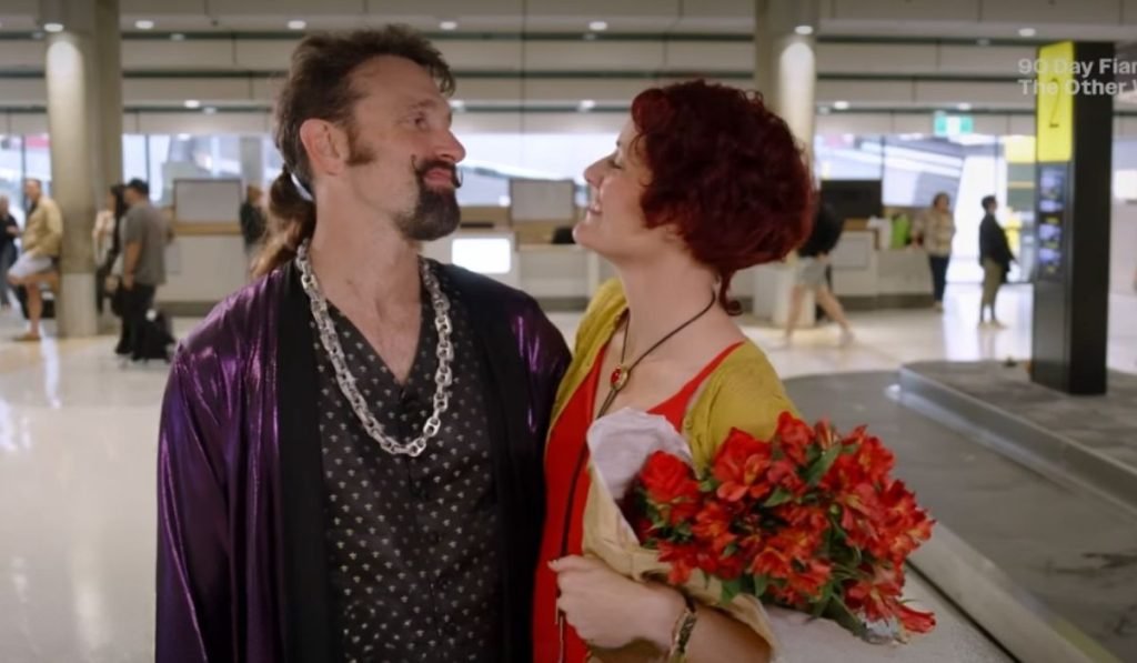 Nigel and Andi Jane smiling at each other at the airport in Brisbane