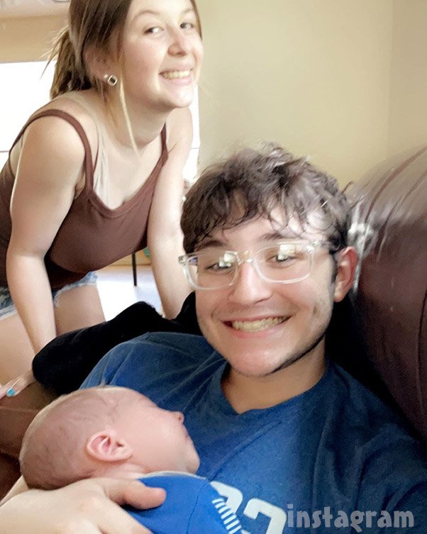 Kayleigh Weathers and Graham Grissom sitting together on a couch, smiling