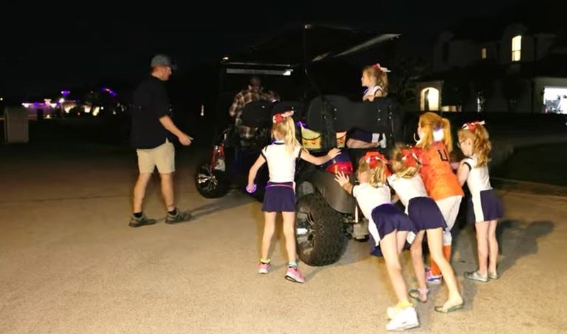 The Busby quints pushing a broken-down golf cart on Halloween night 2022