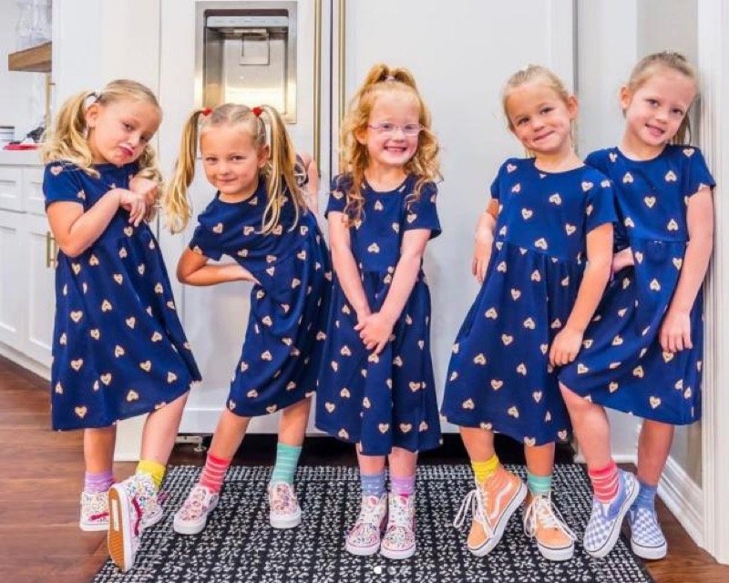 The five Busby quints in matching navy dresses in November 2022